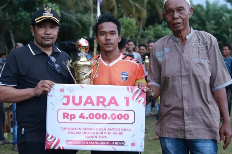 Camat Manggeng Ridhawiyardi (kiri) didampingi Keuchik Lhok Pawoh Amiruddin (kanan) menyerahkan piala dan bonus kepada kapten kesebelasan Desa Kedai dalam laga final turnamen HUT ke 80 Republik Indonesia di Lapangan Hijau Desa Lhok Pawoh, Kecamatan Manggeng, Kabupaten Abdya, Jumat (22/8/2025) sore ke