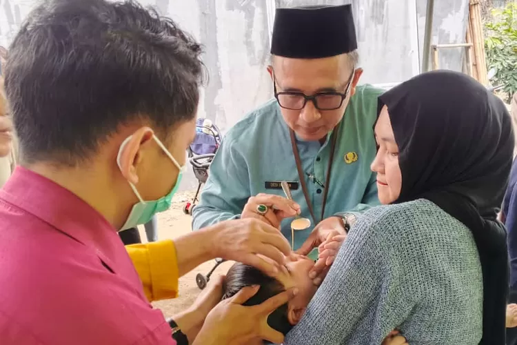 Kasi Kemasyarakatan Kelurahan Cinangka, Dedi Irawan saat memberikan vitamin pada anak saat melakukan peninjauan ke Posyandu RW 2 Kelurahan Cinangka, Kecamatan Sawangan (RISKY DWI LESTARI/RADAR DEPOK)