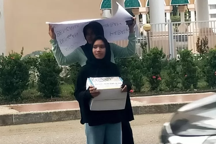 Ditengah rintik hujan, dua pelajar SMKN 1 Bungku Tengah menggalang dana untuk korban bencana alam di Sumatra  (One-Metrosulteng)