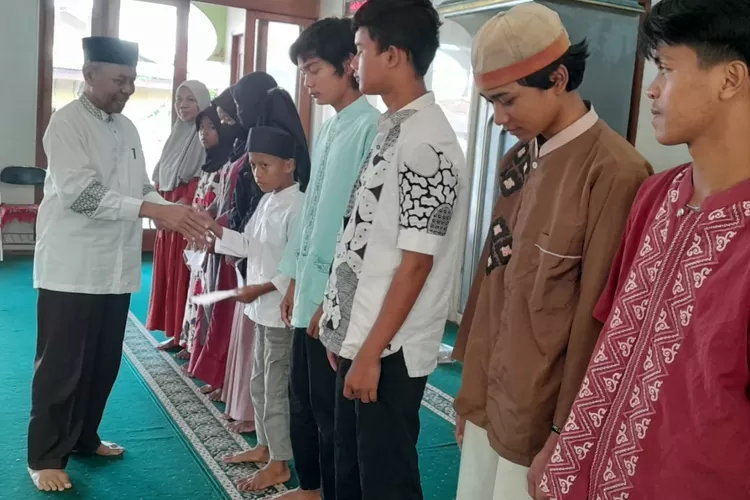 MENYALURKAN : Ketua Umum Yayasan Anak Yatim At-Taqwa, Kostia Permana, saat memberikan santunan anak yatim dan duafa, berlangsung di Masjid Jami Baiturrahman, Kampung Lio, RT5/19 Kelurahan Depok, Kecamatan Pancoranmas, Kota Depok, Minggu (7/7). (ALDY RAMA/RADAR DEPOK)