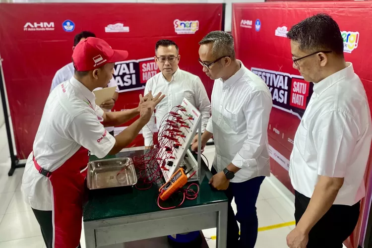 Marketing Director AHM Octavianus Dwi bersama General Manager Corporate Communication AHM Ahmad Muhibbuddin dan General Manager Technical Service AHM V.H. Kunsala Krishna sedang mendengarkan penjelasan salah satu peserta Festival Vokasi Satu Hati 2024 pada uji praktik elektrikal.