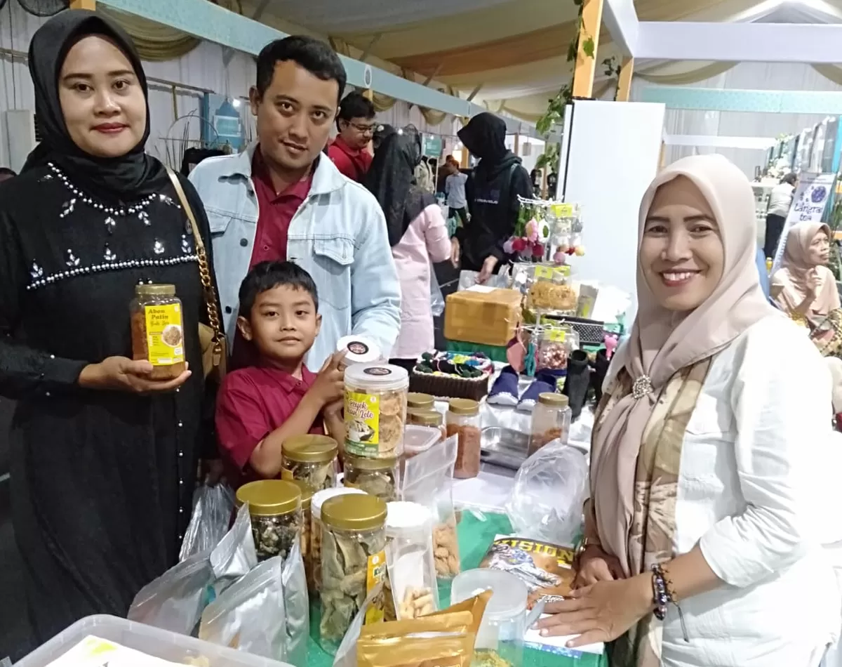 Ana Qomariah (kanan) dengan produk-produk olahannya di stan pameran. (SketsaNusantara.id/As'ad Choirudin)